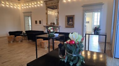 Sala interna di Villa Ciani con tavoli apparecchiati e illuminazione calda per eventi.