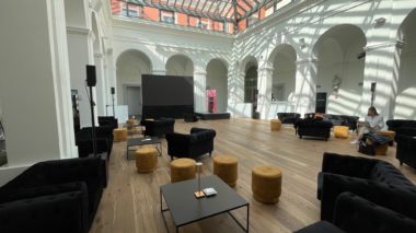 Sala eventi luminosa con soffitti decorati e pavimento chiaro ricavata nel chiostro centrale di Asilo Ciani.